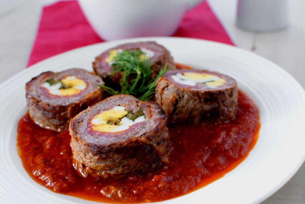 Saboroso rocambole de carne recheado com presunto e queijo, acompanhado de um molho de tomate delicioso! Você vai amar!