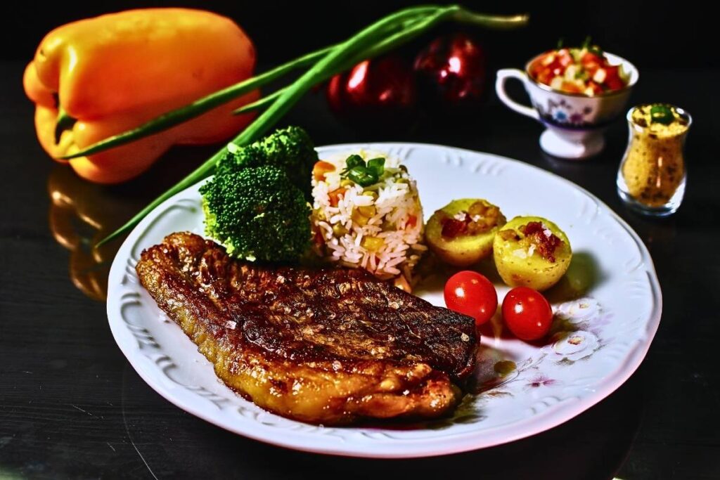 Descubra como preparar um suculento Bife de Chorizo acompanhado de tomates assados e farofa crocante.